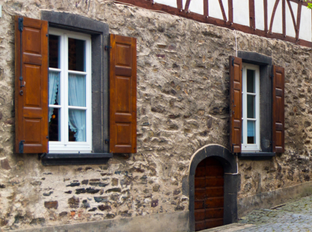 Holzfenster im Altbestand mit Wärmeschutzverglasung und aufgesetzten Sprossen, Fensterläden mit Füllung in nussbaumfarben lasierter Fichte